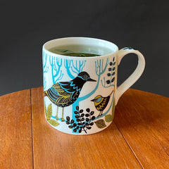 Bone china mug printed with birds containing peppermint tea