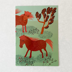 lush designs card with orange ponies on a green background